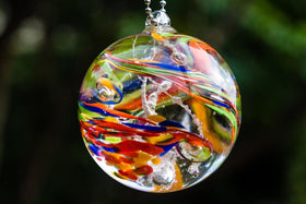 rainbow confetti orb with cremation ash hanging in sun